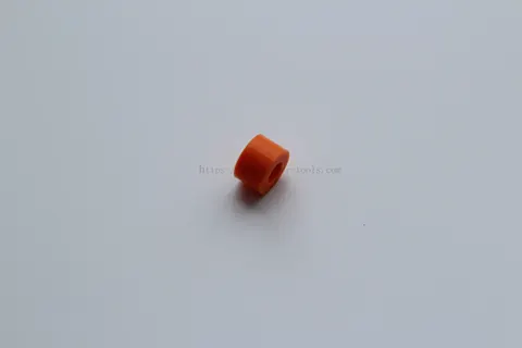 Small orange moulded seal photographed against a plain white background