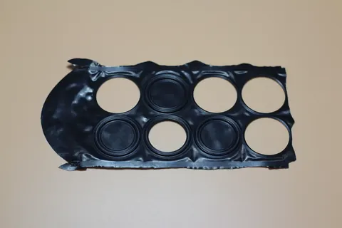 Black moulded plastic frame with multiple circular apertures