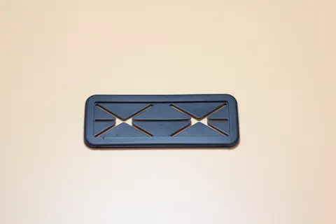 Black moulded plastic component with a fine comb of parallel teeth