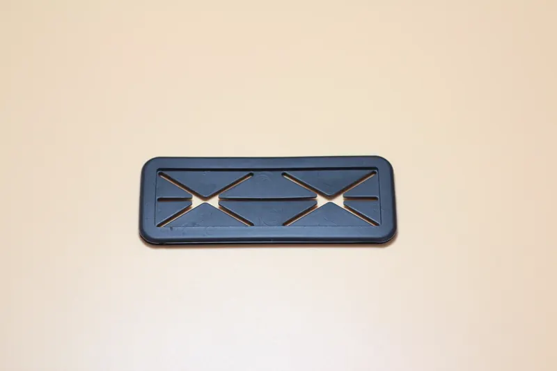 Black moulded plastic component with a fine comb of parallel teeth