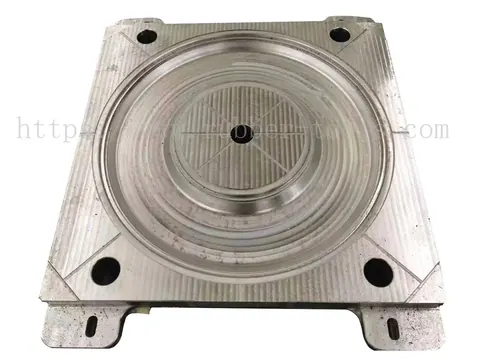 Large machined steel mould plate with a circular central cavity and guide pins